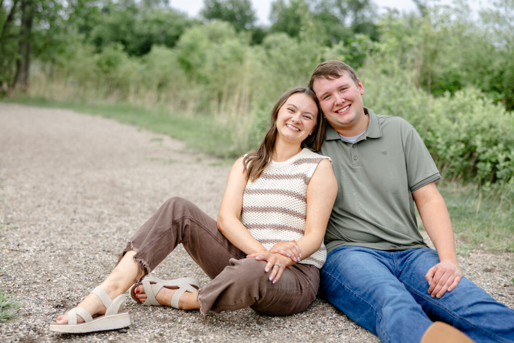 couple sitting on trail in sioux falls for engagement photos